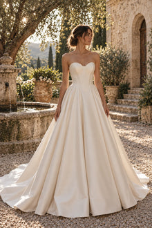Robe Margaux vue de face : satin ivoire, bustier sans bretelles drapé en cœur, taille en pointe et très grande jupe plissée