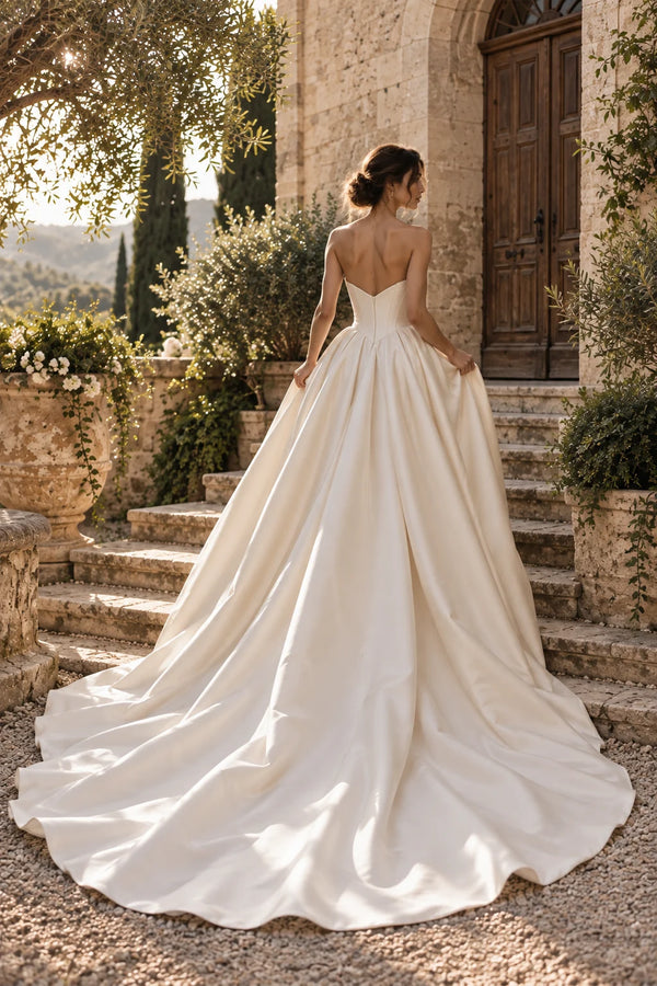 Robe Margaux vue de dos sur des marches de pierre : dos du bustier et traîne de cour en satin